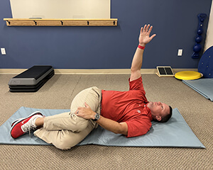 photo of a man laying on his side stretching his torso