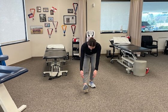 Therapist demonstrating walking scoops stretches.