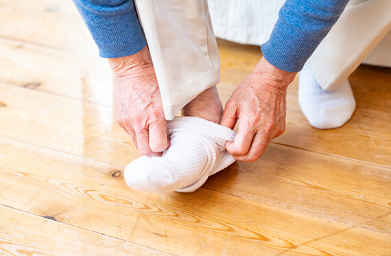 Close up of a man putting a sock on
